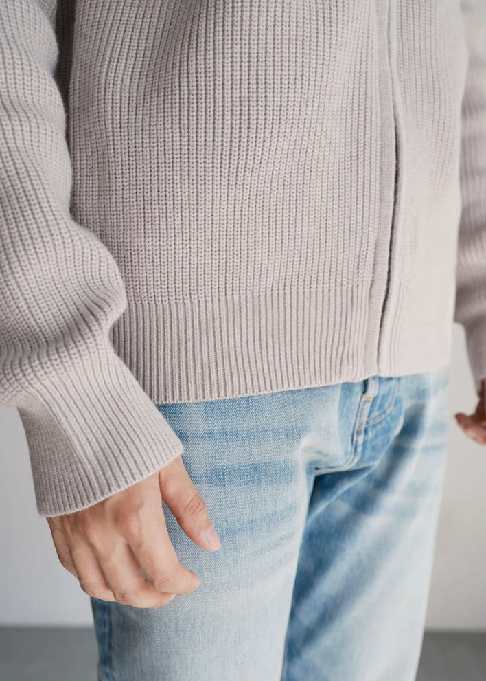 Macro shot of the Warm Grey rib-knit cuffs and hem, designed to remain resilient and sharp even after machine washing